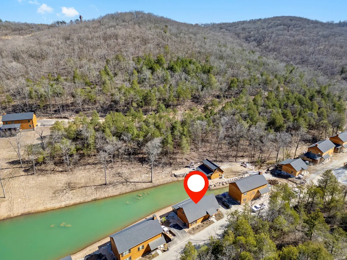 A serene lakeside scene with wooden cabins nestled among trees, clear water reflecting the sunrise, and ample space for fishing, hiking, or enjoying nature. The atmosphere is calm and inviting, perfect for reconnecting with the outdoors.